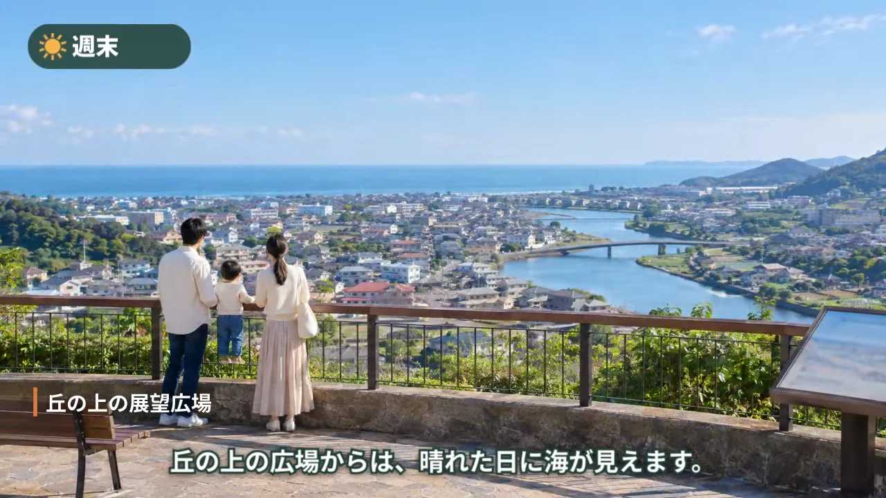作例のエリア紹介動画で、丘の上の展望広場から街と海を眺める家族の場面